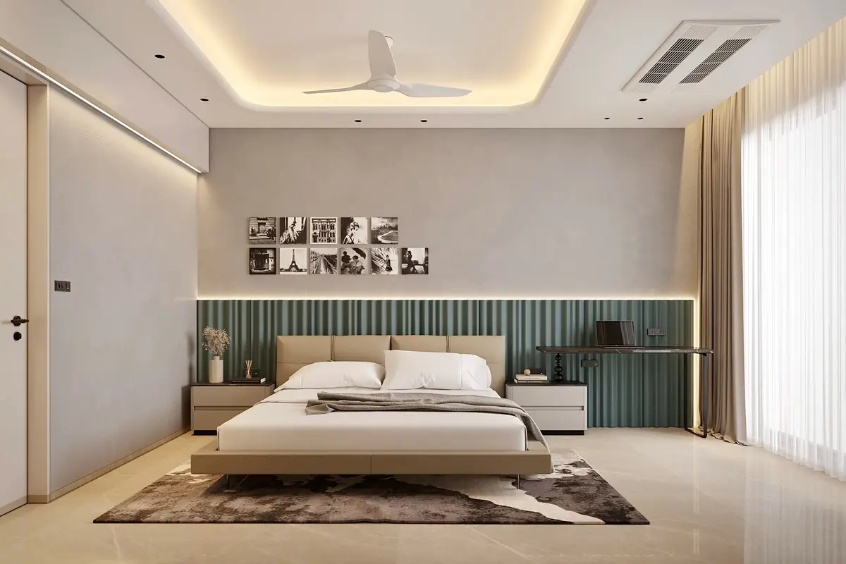Bedroom with a sage green fluted headboard, framed photographs and a cove-lit ceiling