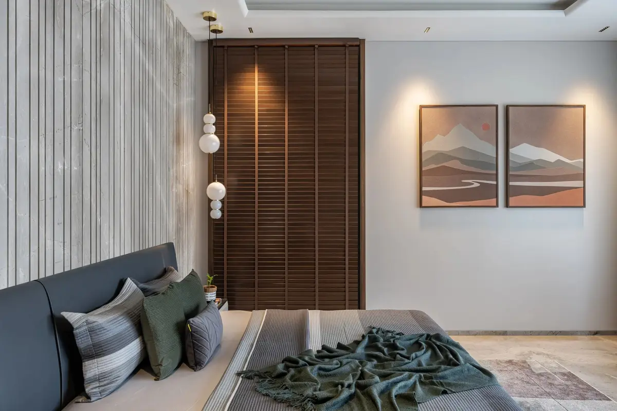 Bedroom with a fluted stone wall, timber doors and paired landscape artworks